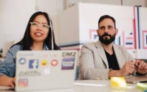 Two People Sitting Together with Laptops