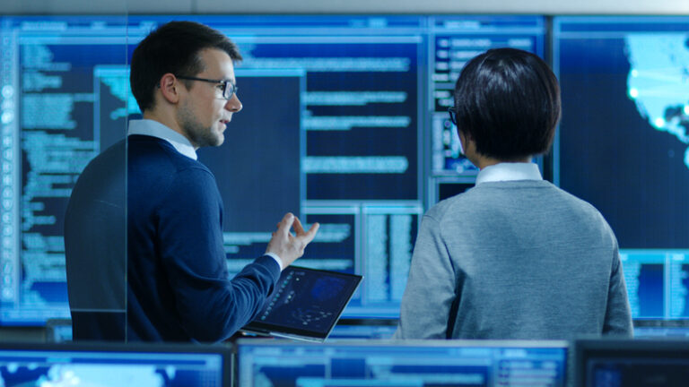 two it specialists speaking in a system control room